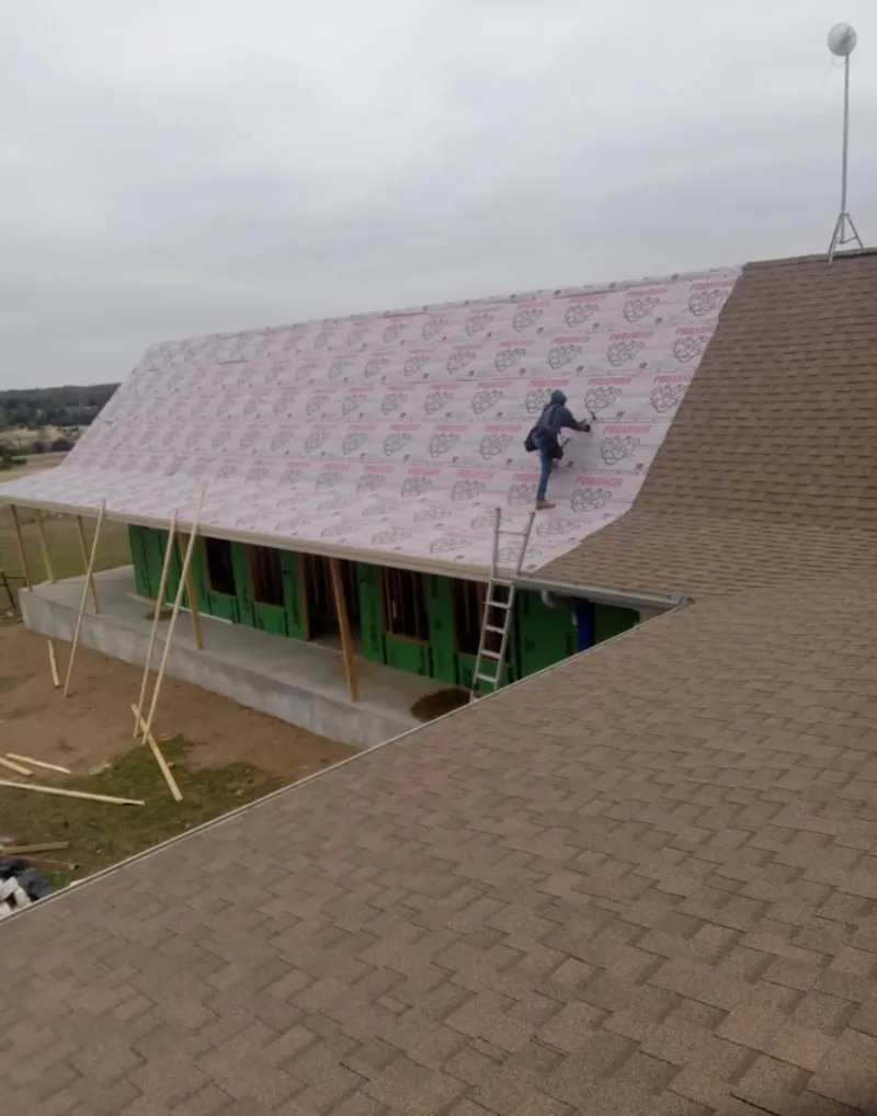 Worker preparing underlayment for a metal roof installation in Miami